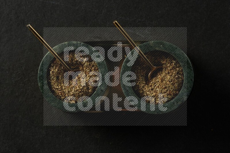 black and white round marble containers filled with herbs on gray textured countertop