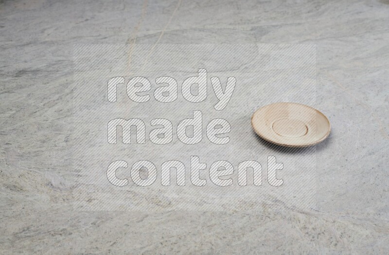 A beige pottery plate on grey marble background
