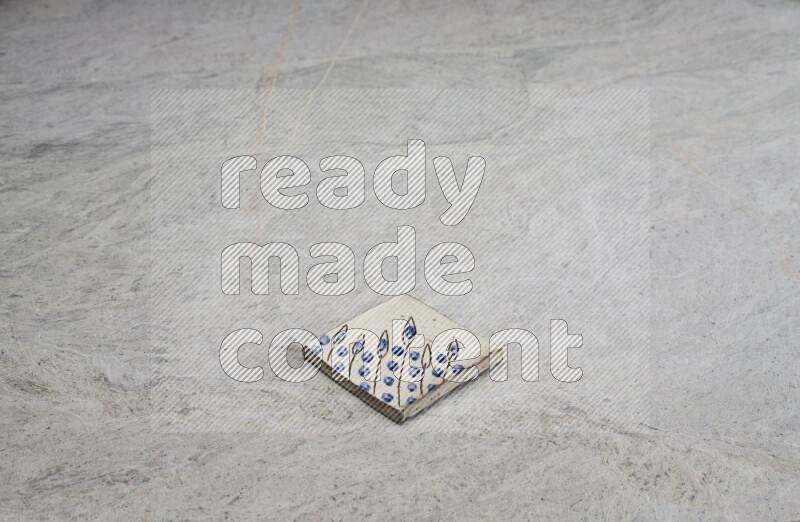 Top view shot of a pottery coaster\ tile on beige marble flooring