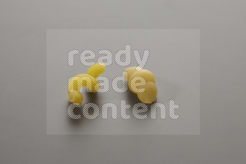 Twist pasta with other types of pasta on grey background