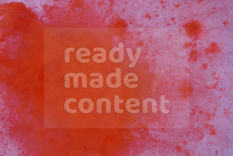 The image captures a dramatic splatter of red paint over a white backdrop