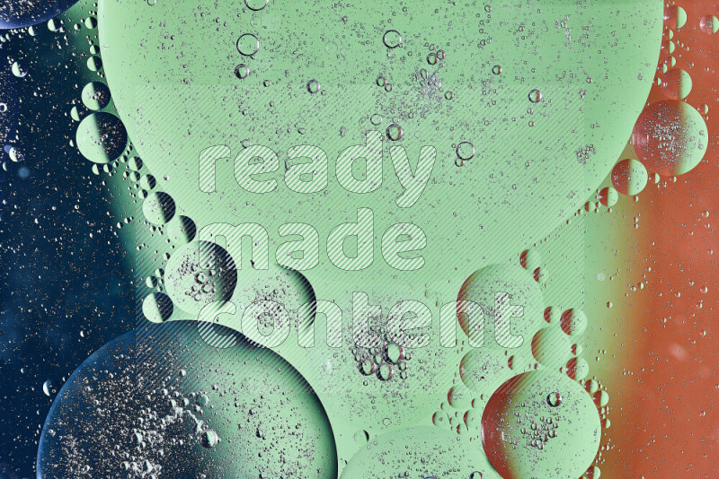 Close-ups of abstract oil bubbles on water surface in shades of orange, green and blue