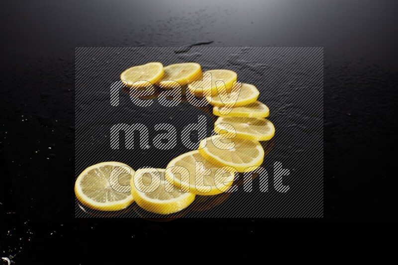 Lemon slices with water drops, and droplets on black background