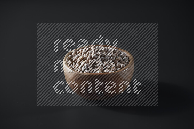 Chickpeas in a wooden bowl on grey background