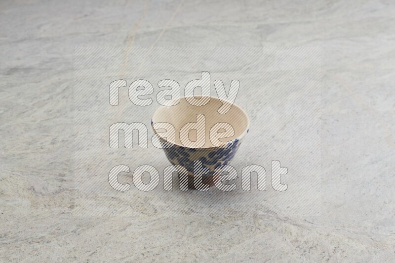 A multicolored pottery bowl on grey marble background
