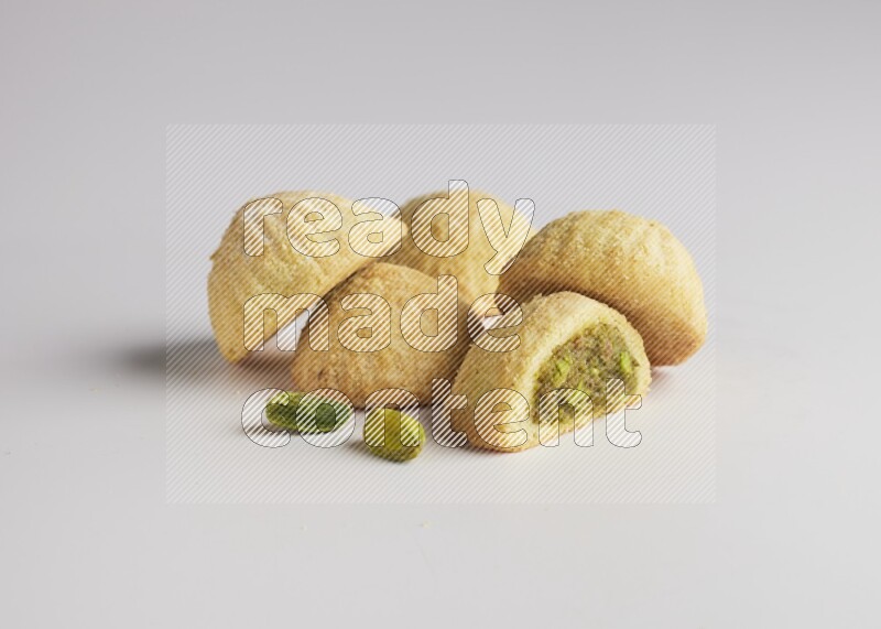 Five Pieces of Maamoul filled with pistachio  paste one of them is cut direct on white background