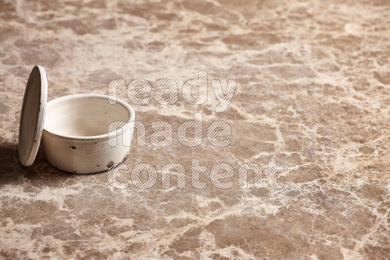 A white pottery bowl on beige marble background