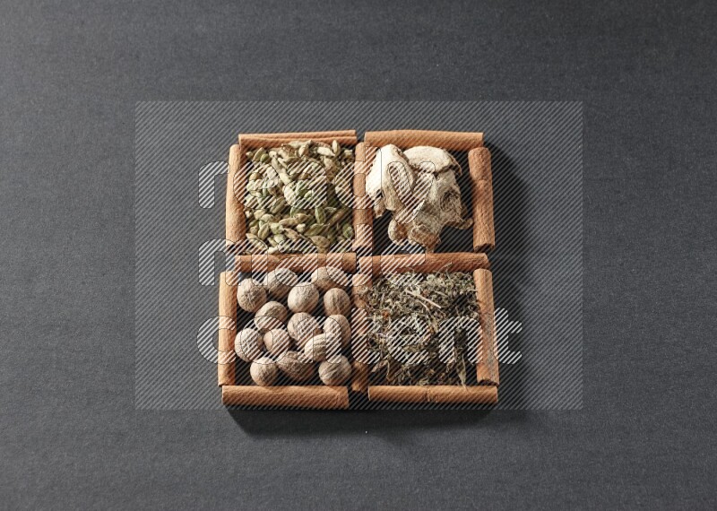 4 squares of cinnamon sticks full of dried basil, cardamom, dried ginger and nutmegs on black flooring