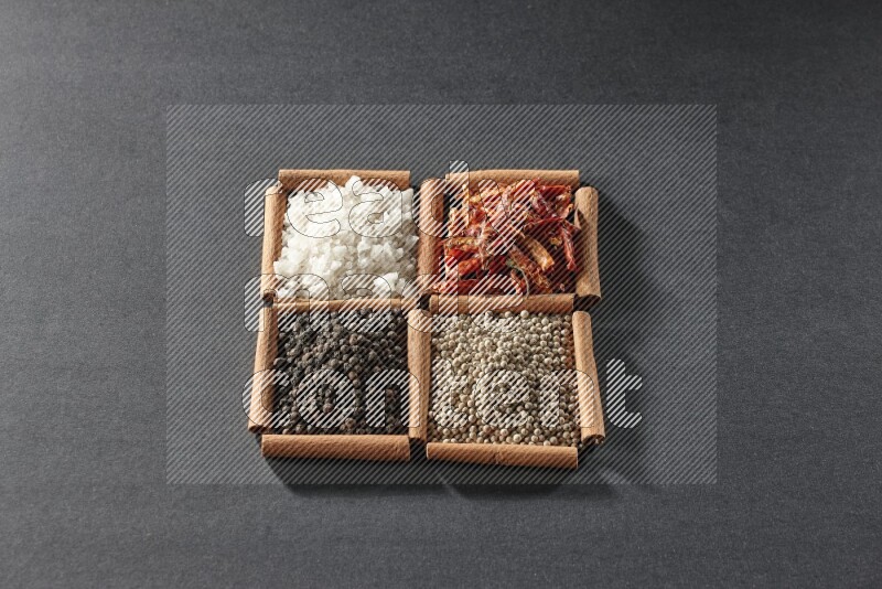 4 squares of cinnamon sticks full of black pepper, white pepper, dried red chilis and white salt on black flooring
