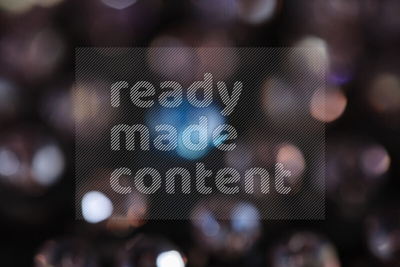 Rose and blue transparent crystal beads scattered on a black background