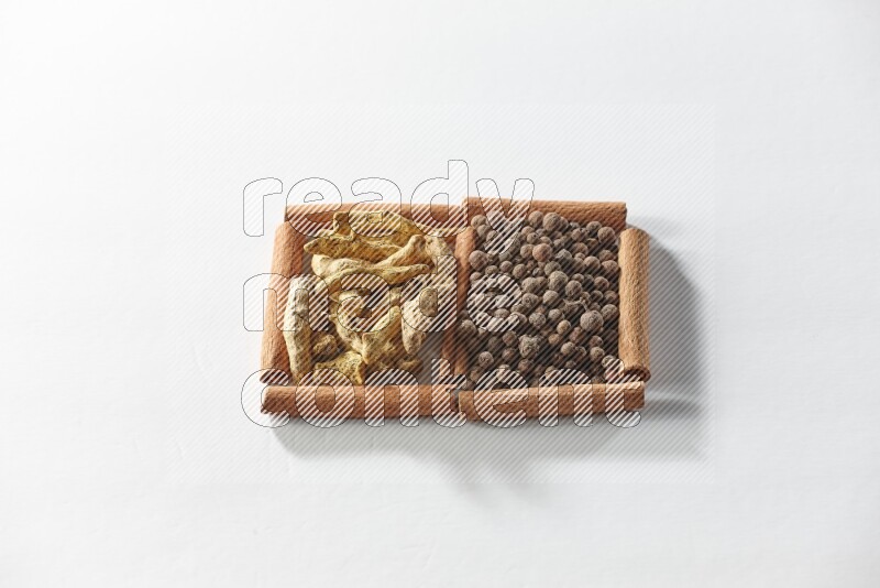 2 squares of cinnamon sticks full of allspice and turmeric fingers on white flooring