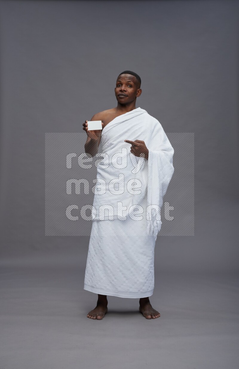 A man wearing Ehram Standing holding ATM card on gray background