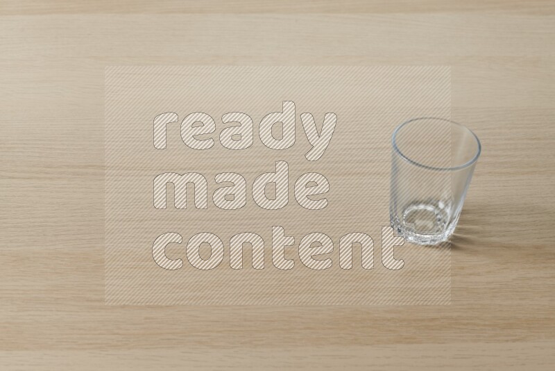 An empty glass cup on light wooden background