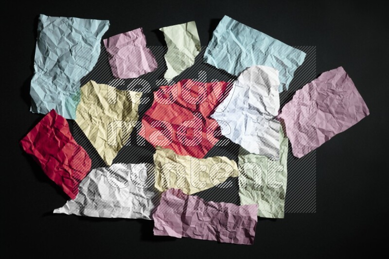 Crumpled multicolored paper on black background
