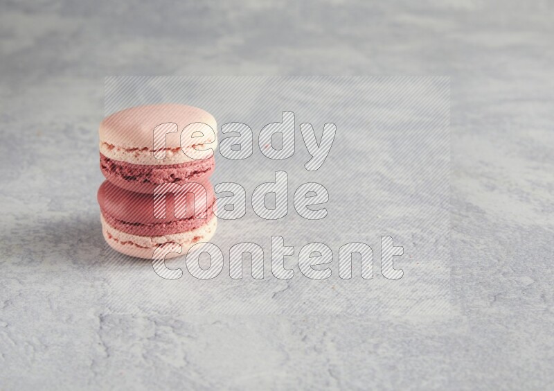 45º Shot of two Pink Litchi Raspberry macarons  on white  marble background