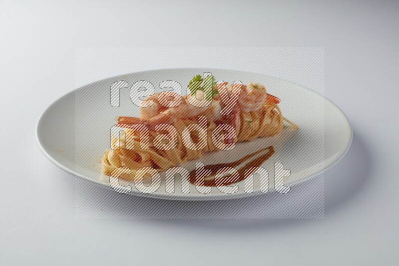 Fettuccini red sauce pasta with shrimp in a white plate on a white background