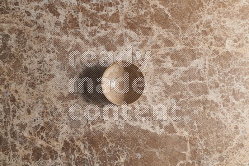 A beige pottery bowl on beige marble background