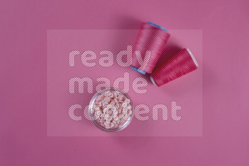 مجموعة من أدوات الخياطة والتفصيل زهرية اللون على خلفية زهرية