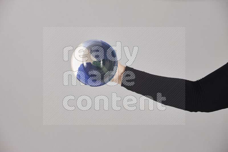 A woman in black abaya holding different pottery essentials in different positions