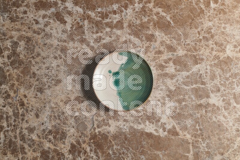 A decorative pottery plate on beige marble background