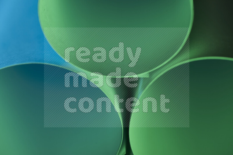 The image shows an abstract paper art with circular shapes in varying shades of green and blue