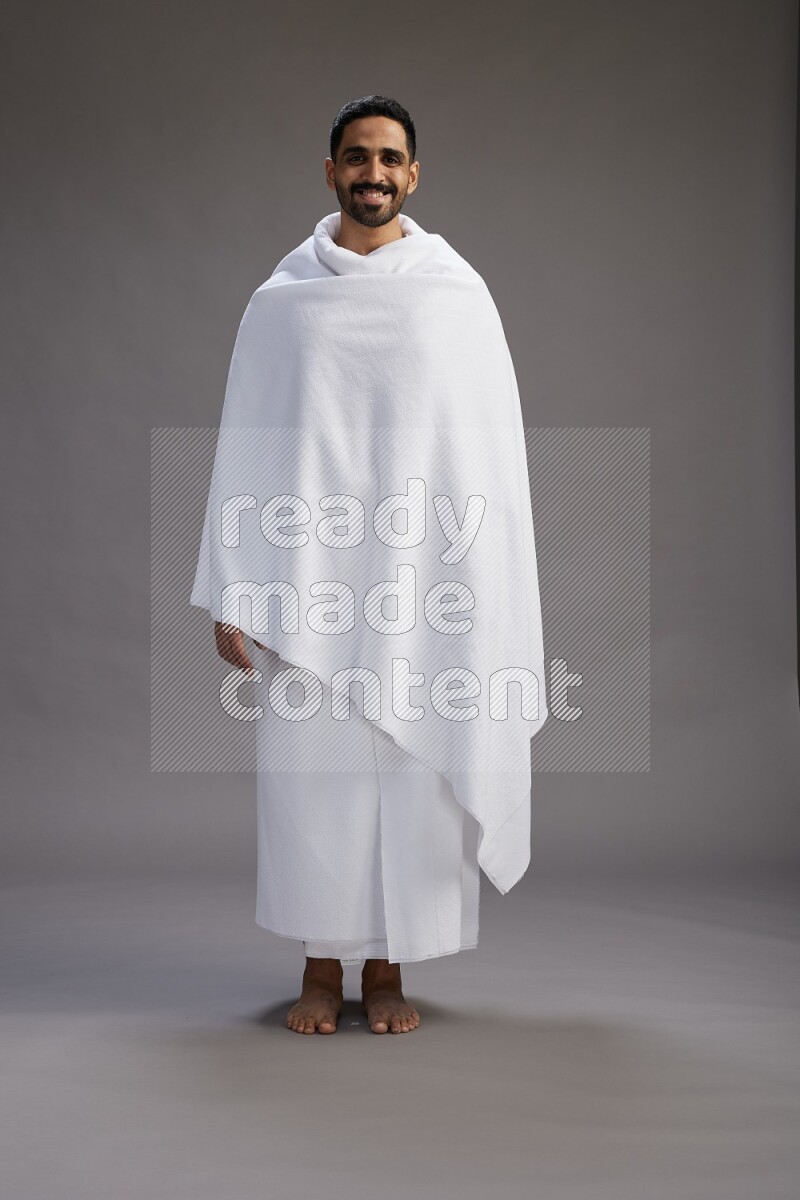 A man wearing Ehram Standing Interacting with the camera on gray background