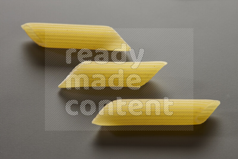 Penne pasta on grey background