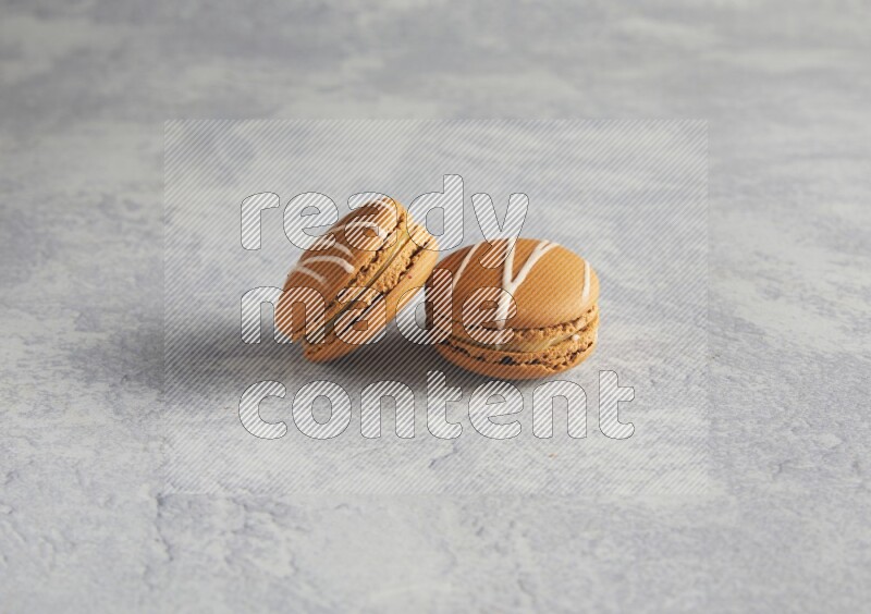 45º Shot of two Brown Irish Cream macarons  on white  marble background