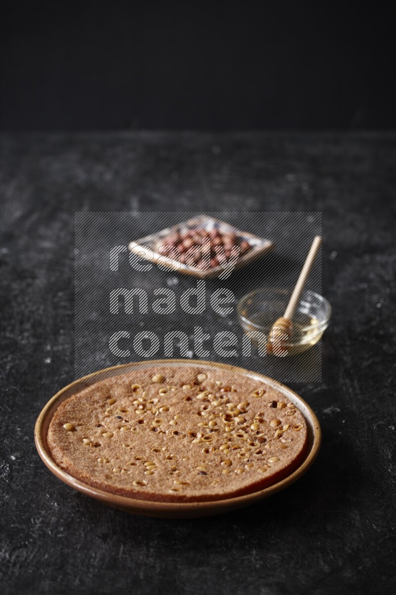 Basbousa with nuts and honey in a dark setup