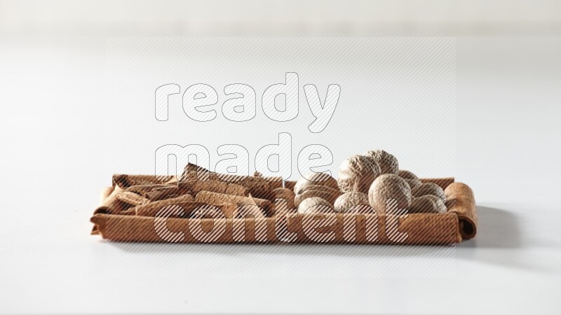 2 squares of cinnamon sticks full of cinnamon and nutmeg on white flooring