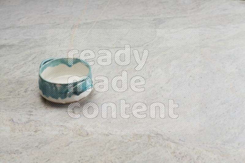A multicolored pottery bowl on grey marble background