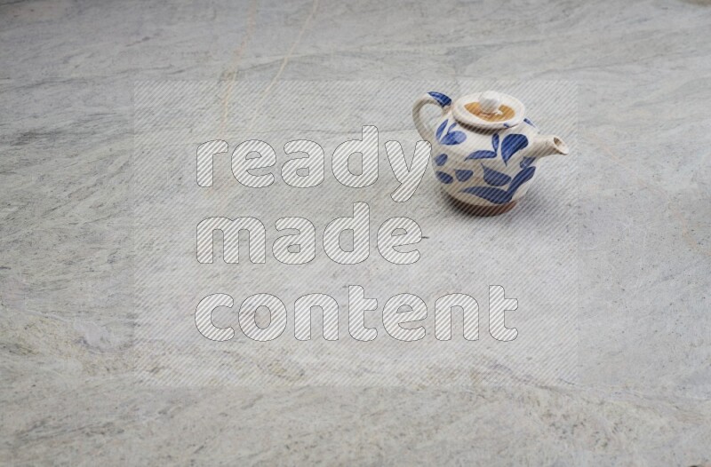 A pottery teapot on grey marble background