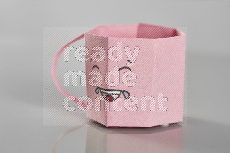 Origami cup on grey background