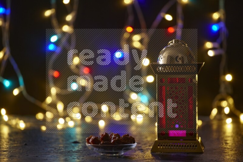 A traditional ramadan lantern surrounded by glowing fairy lights in a dark setup