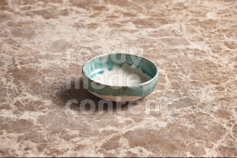 A multicolored pottery plate on beige marble background