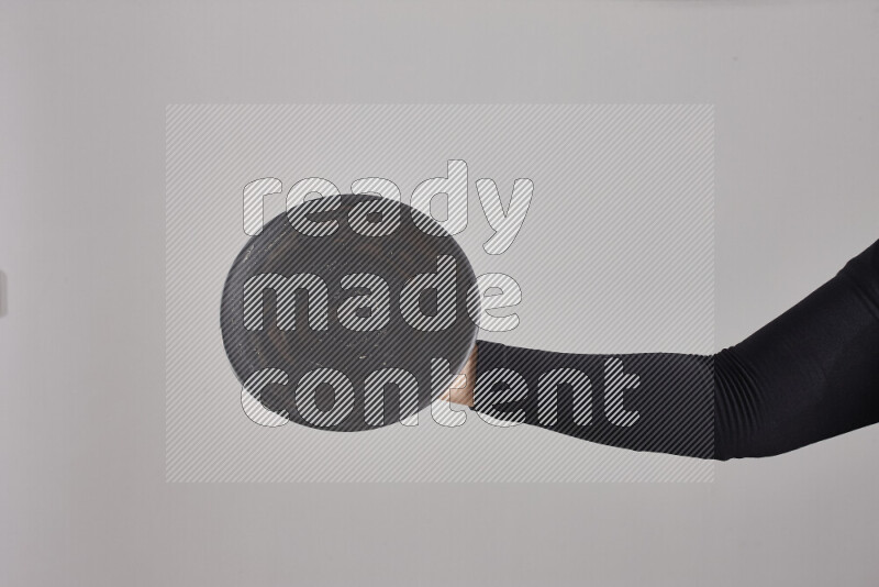 A woman in black abaya holding different pottery essentials in different positions