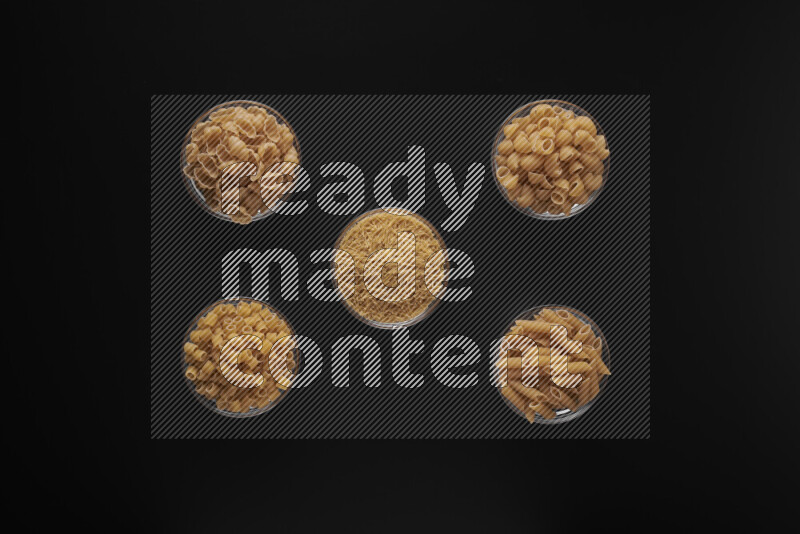 أنواع مختلفة من المعكرونة في أوعية زجاجية علي خلفية سوداء