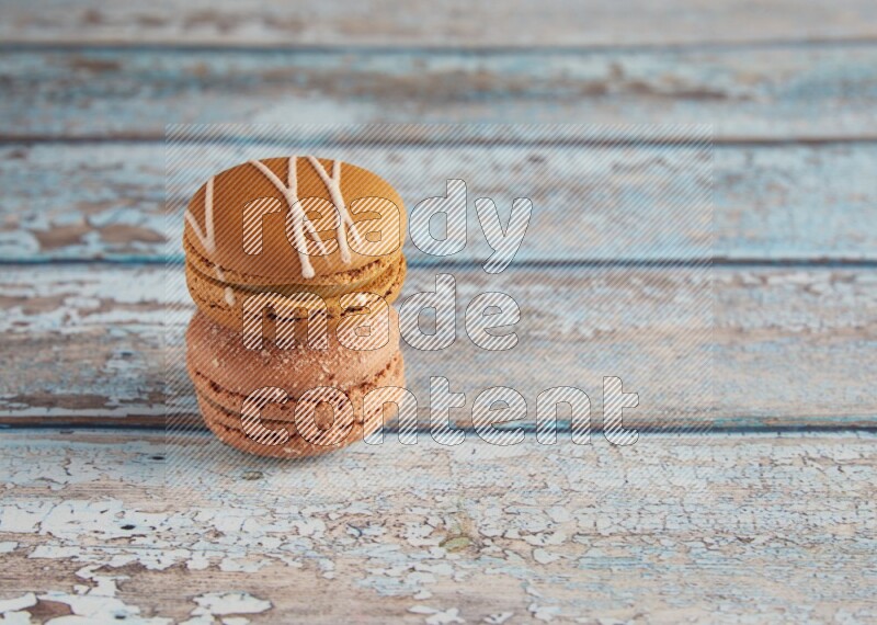 45º Shot of of two assorted Brown Irish Cream, and Brown Hazelnuts macarons  on light blue background