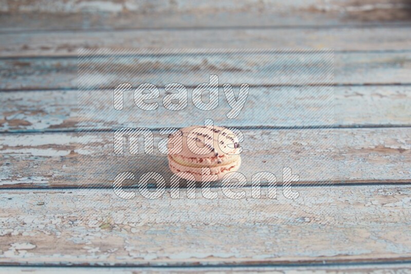 45º Shot of pink orange blossom macaron on light blue wooden background