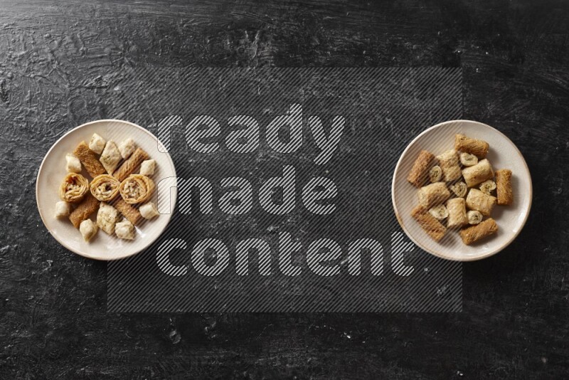 حلويات شرقية في أطباق فخارية علي خلفية سوداء خشبية