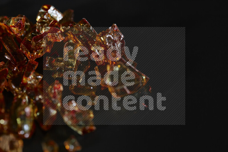 قطع زجاج برتقالية شفافة متناثرة على خلفية سوداء