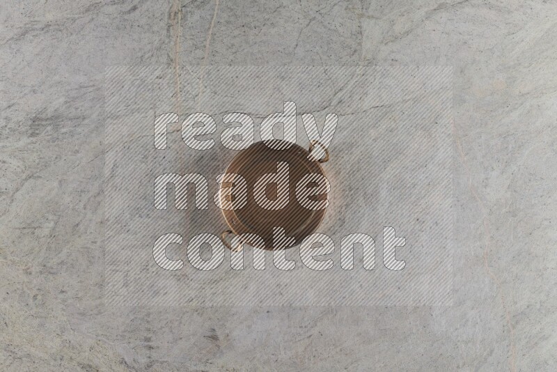 A small copper pan on grey marble background