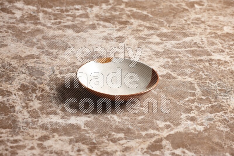 A multicolored pottery plate on beige marble background