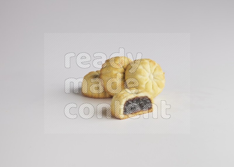 Four Pieces of Maamoul filled with date one of them is cut direct on white background