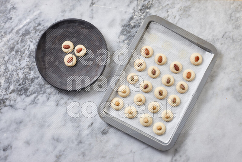 Ghoriba step by step with its ingredient, flour, powdered sugar, ghee and nuts on grey marble background