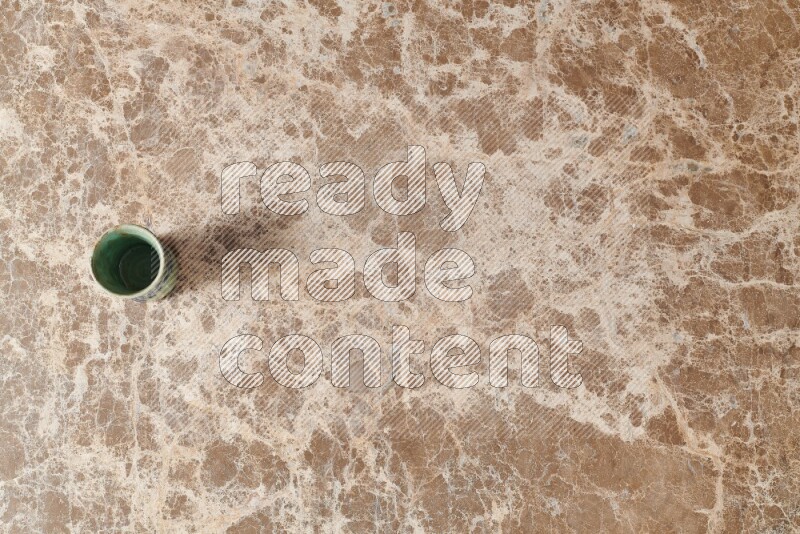 A pottery cup on beige marble background