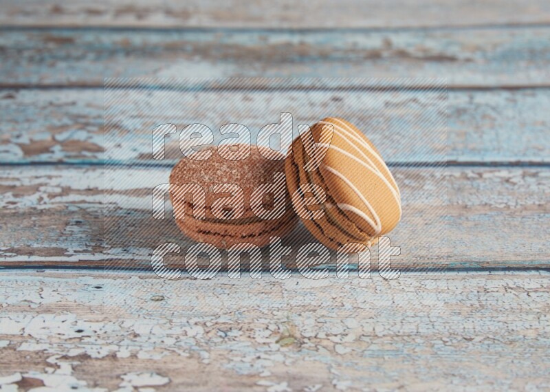 45º Shot of of two assorted Brown Irish Cream, and Brown Hazelnuts macarons  on light blue background