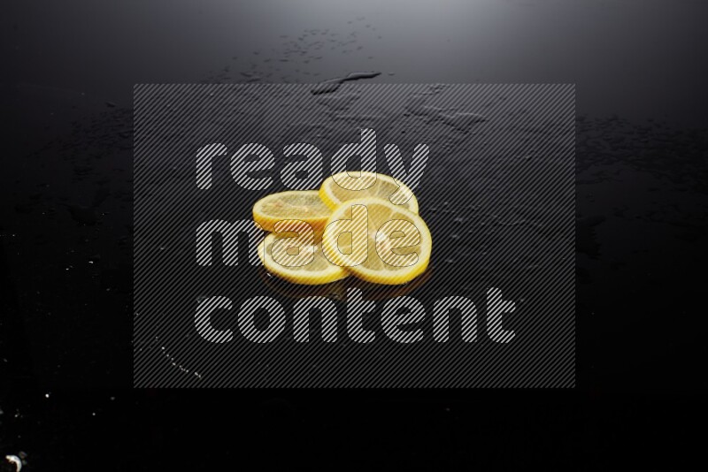 Lemon slices with water drops, and droplets on black background