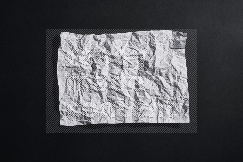 Crumpled notebook sheet on black background