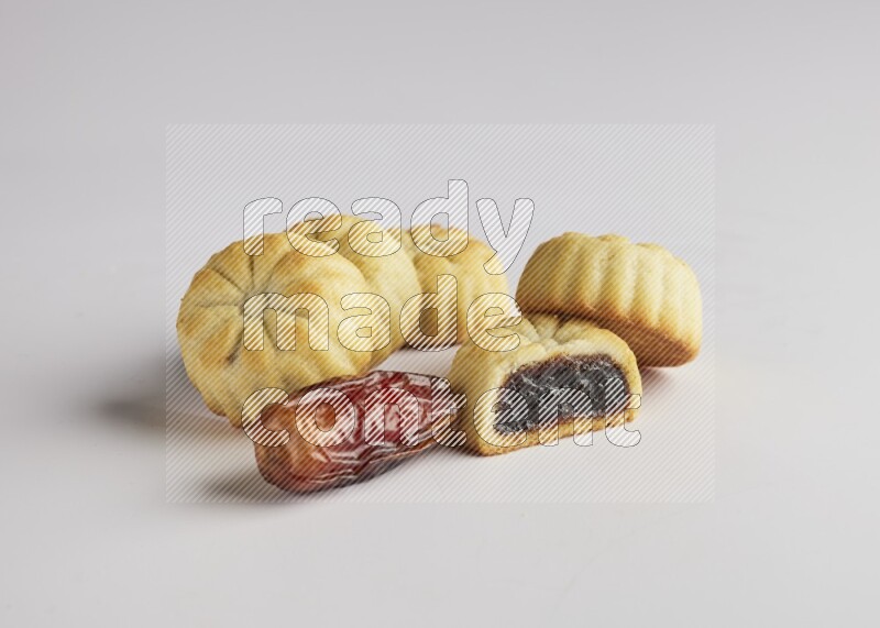 Five Pieces of Maamoul filled with date one of them is cut direct on white background
